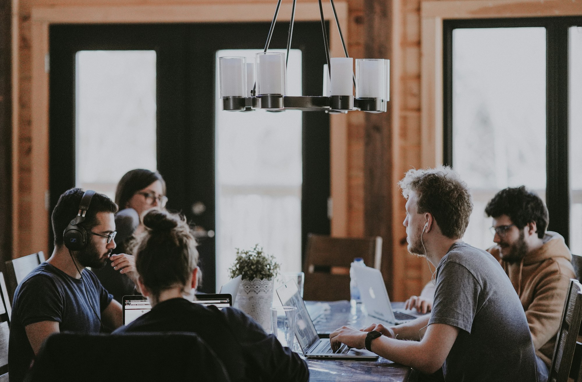Menschen arbeiten gemeinsam an einem Tisch mit Laptops
