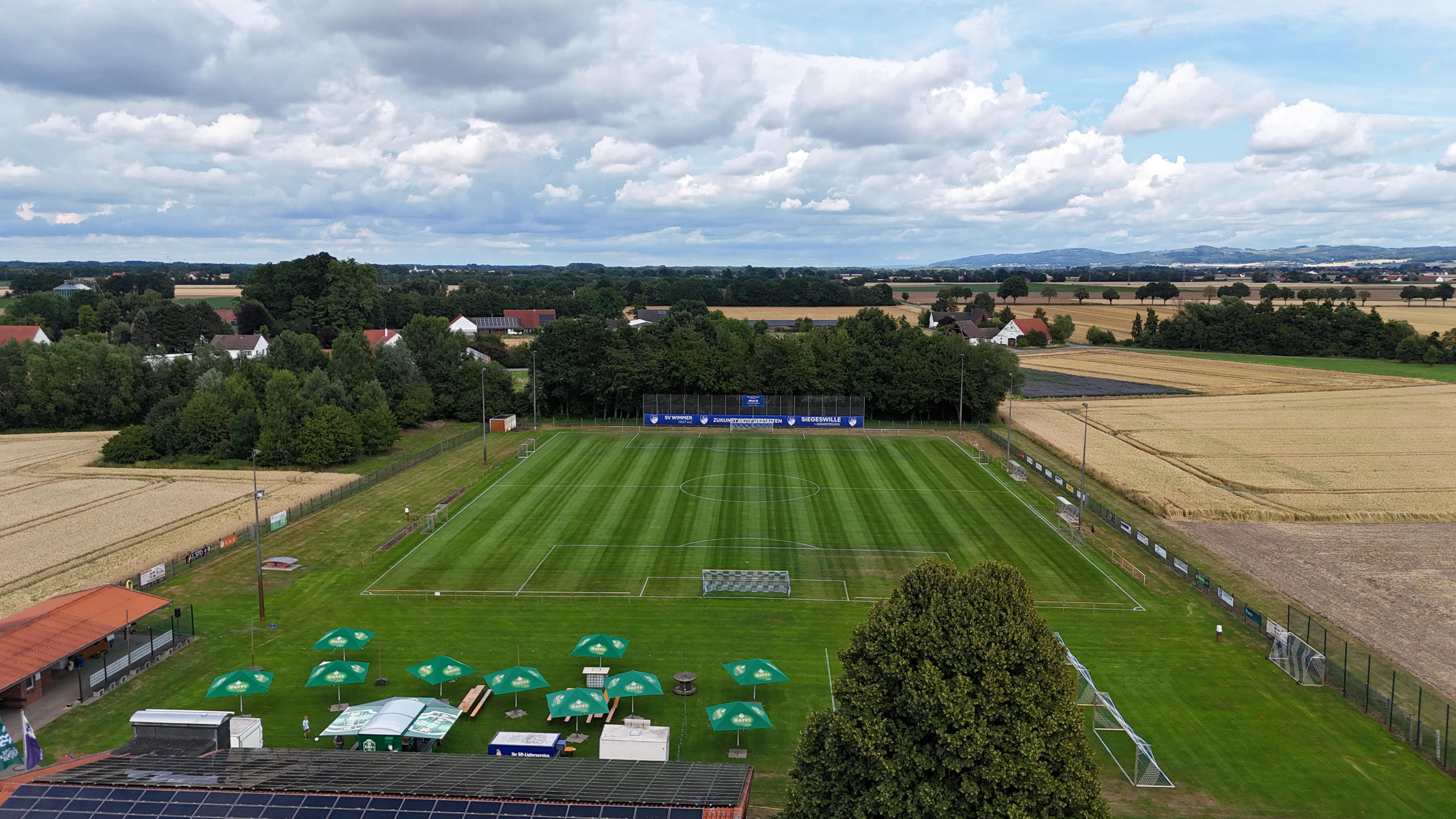 Luftaufnahme des Sportplatzes mit Spielfeld, Vereinsheim und Festzelt